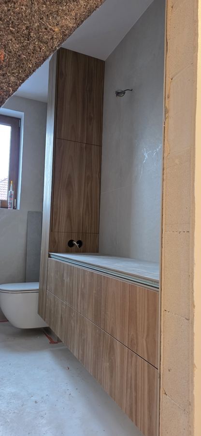 Łazienka w orzechu. Ławka i wysoka zabudowa